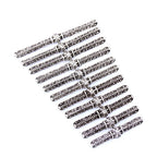 Set of ornate silver metal pen-shaped decorative rods arranged neatly on white background