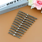 Set of ornate bronze hair clips with rhinestones on a brown surface, decorative accessories