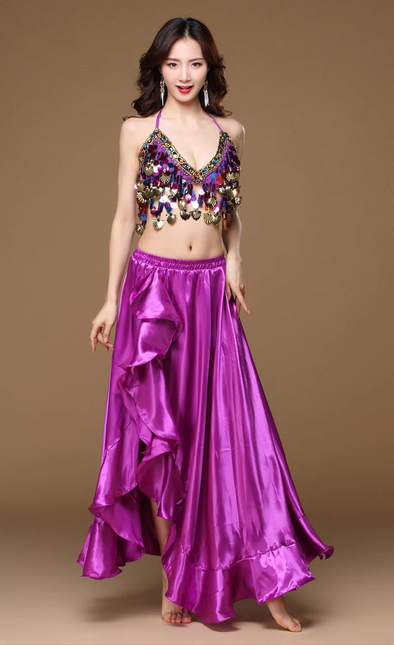 Woman wearing purple belly dance costume with sequin top and flowing satin skirt