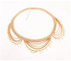 Gold statement necklace with layered chains and leaf-shaped pendants on white background