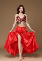 Woman in red belly dance costume with sequin top and flowing satin skirt