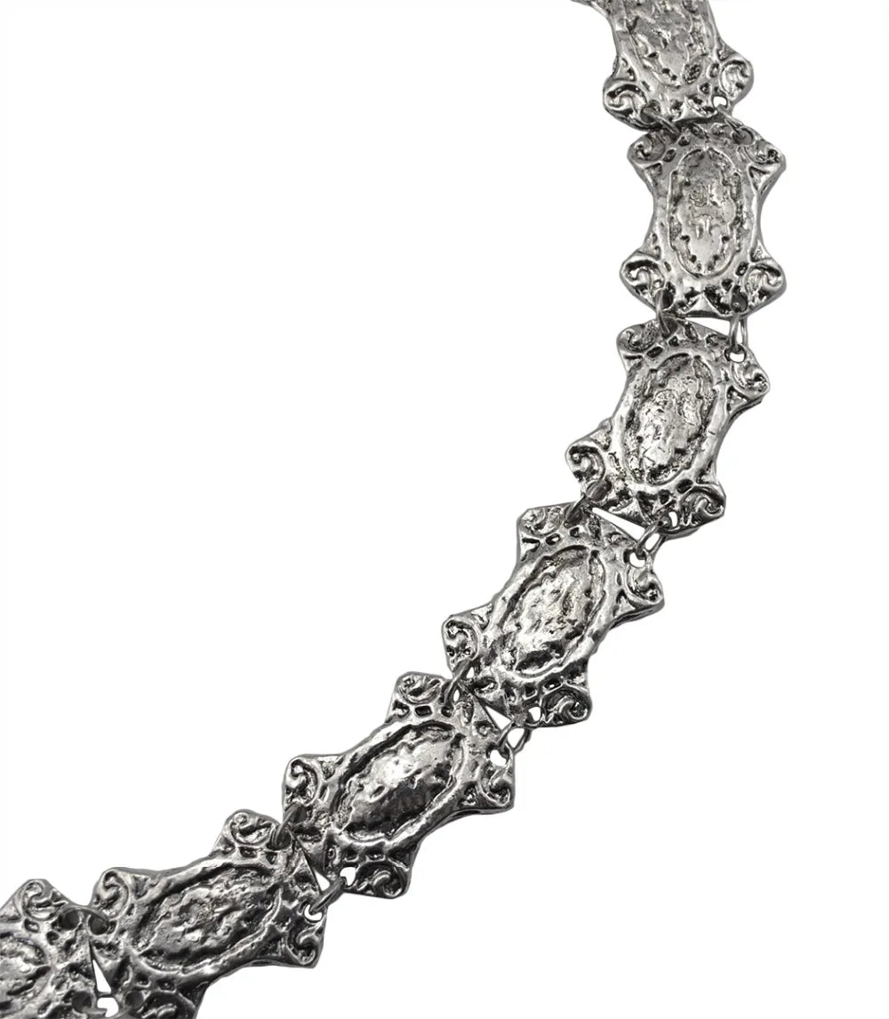 Textured silver chain necklace with ornate, vintage-style links on a white background.