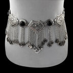 Silver boho coin belt with ornate details and hanging chains, displayed on a mannequin.