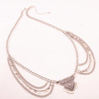 Layered silver chain necklace with geometric pendant and coin accents on white background