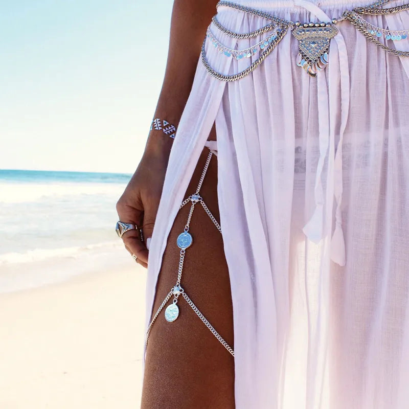 Woman wearing boho silver body chain jewelry and sheer sarong on the beach