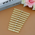 Set of ornate gold metal hair clips with rhinestones on a brown background, decorative accessories