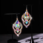 Pair of iridescent crystal chandelier earrings with teardrop shapes on a black background