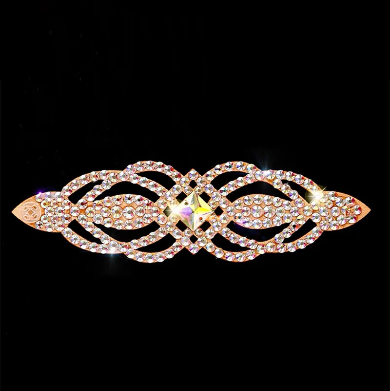 Gold hair barrette with sparkling rhinestones and geometric design on black background