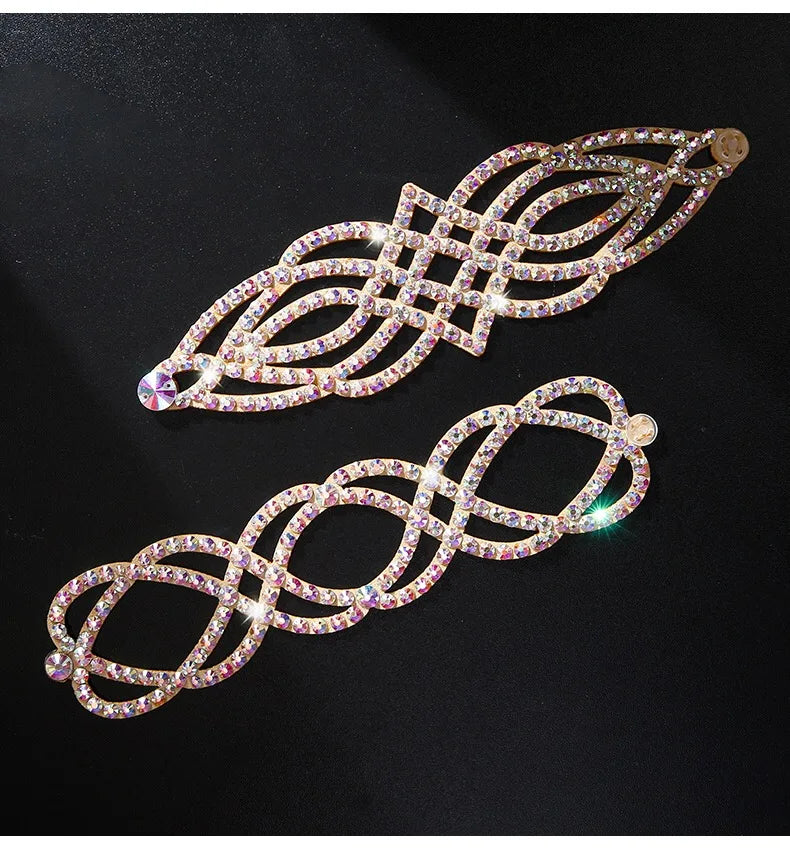 Two gold-tone rhinestone hair clips with geometric patterns on a black background