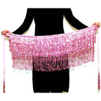 Person holding a pink sequin fringe belly dance hip scarf with tassels against a white background