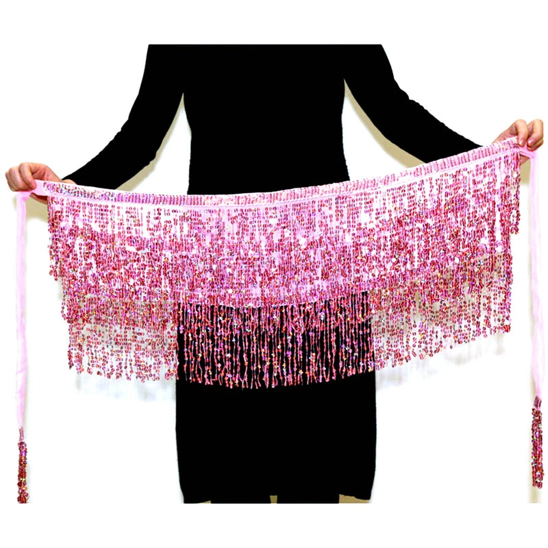 Person holding a pink sequin fringe belly dance hip scarf with tassels against a white background