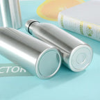 Stainless steel insulated water bottles on a blue surface with a book nearby