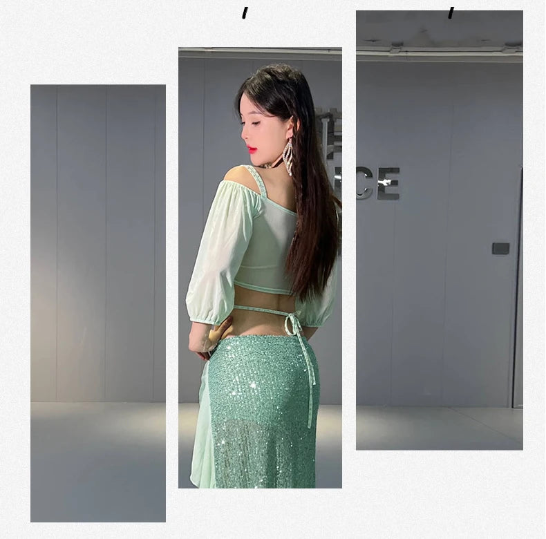 Woman wearing light green sequin skirt and sheer blouse, posing indoors, modern style