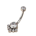 Silver belly button ring with clear gemstones in a paw design on white background