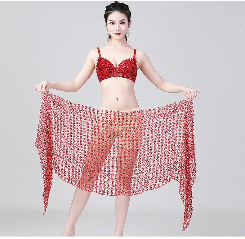 Woman in red embellished bralette and sheer red beaded wrap skirt on light background