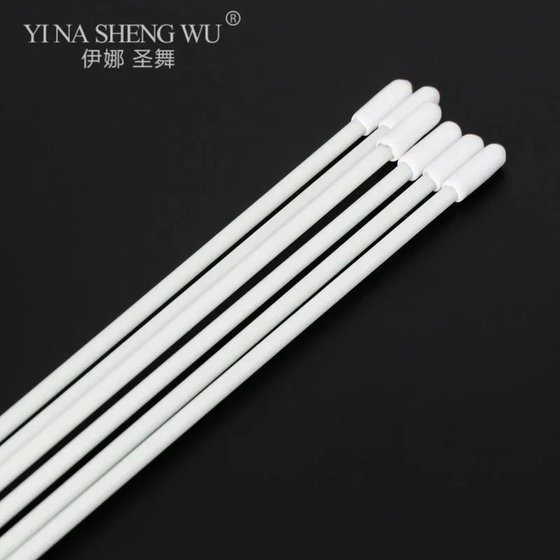Set of white cotton swabs with long handles on a black background
