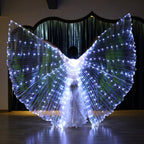Person wearing large LED light up wings costume, illuminated on indoor stage