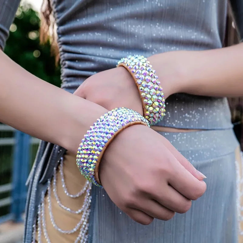 Woman wearing two sparkly rhinestone bracelets with iridescent crystals outdoors
