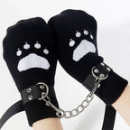 Black paw print mittens with wrist straps connected by a metal chain, novelty accessory