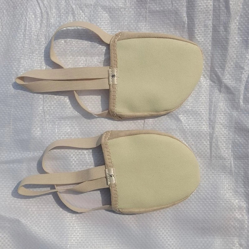 Pair of beige fabric foot pads with elastic straps on a textured surface
