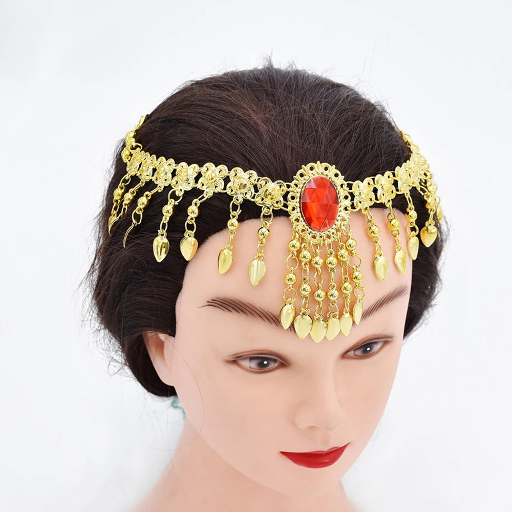 Gold headpiece with red gemstone and dangling charms on mannequin head