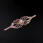 Iridescent rhinestone hair barrette with leaf design on black background