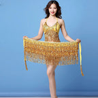 Woman in gold sequin fringe dance costume posing against blue background