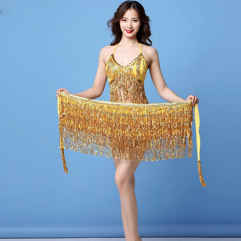 Woman in gold sequin fringe dance costume posing against blue background