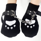 Black paw mittens with white paw print, connected by chain and adjustable wrist straps