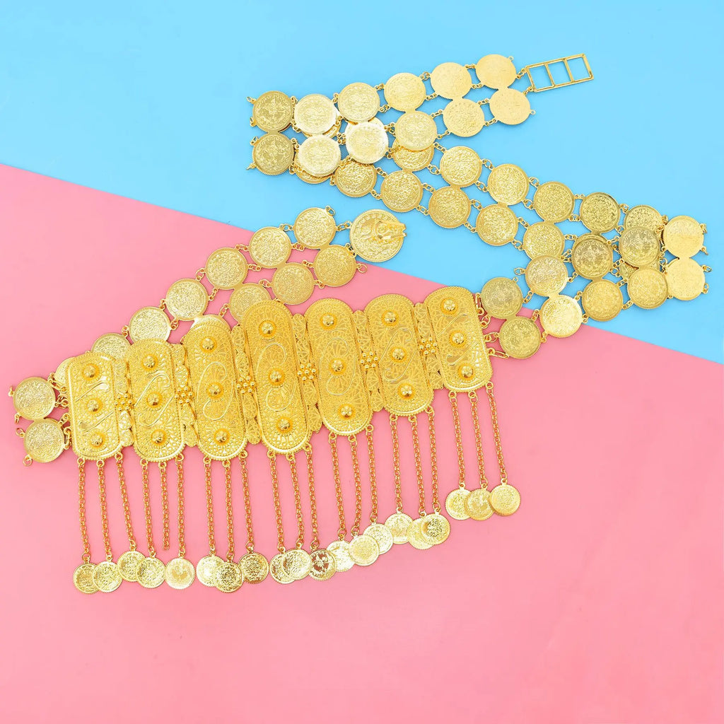 Gold coin belt with intricate engraved details and dangling coins on blue and pink background