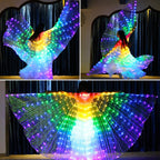 Person dancing with LED light up wings in rainbow colors indoors