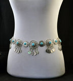 Bohemian silver waist chain with turquoise accents and dangling coin charms on mannequin