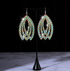 Sparkling teardrop-shaped rhinestone dangle earrings on black display stand