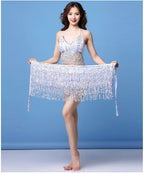 Woman wearing sparkly silver fringe dance costume with matching wrap against blue background