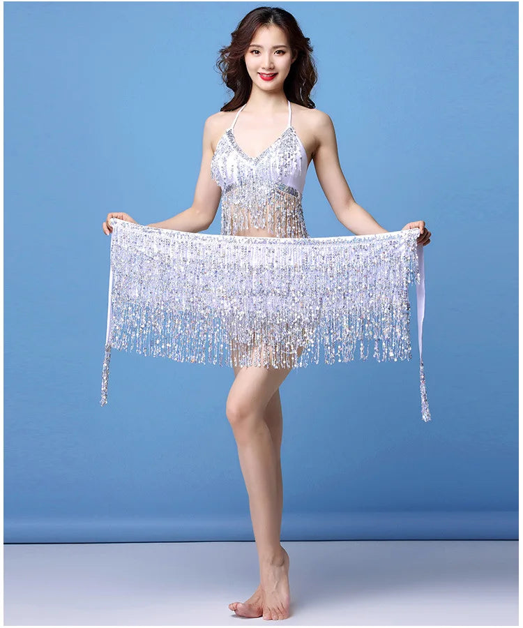 Woman wearing sparkly silver fringe dance costume with matching wrap against blue background