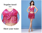 Woman wearing pink sequin tassel dance outfit with halter top and skirt, showing waist detail.