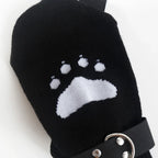 Black mitten with white animal paw print and adjustable strap for outdoor or pet care use