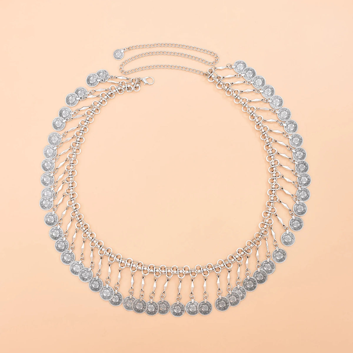 Silver coin choker necklace with layered chains on a peach background
