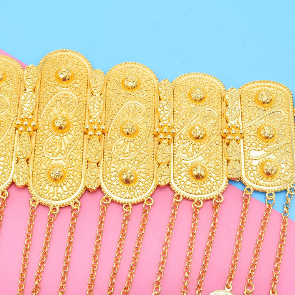 Ornate gold chain belt with intricate patterns and dangling chains on pink and blue background
