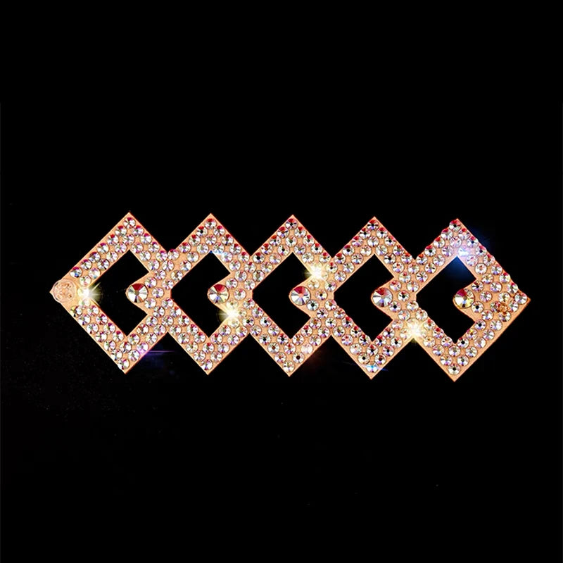 Geometric rhinestone hair clip with gold-tone finish on black background