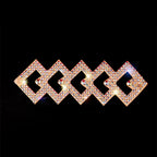 Geometric rhinestone hair clip with gold-tone finish on black background