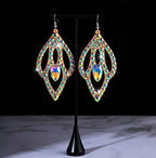 Colorful rhinestone dangle earrings with teardrop design on a display stand