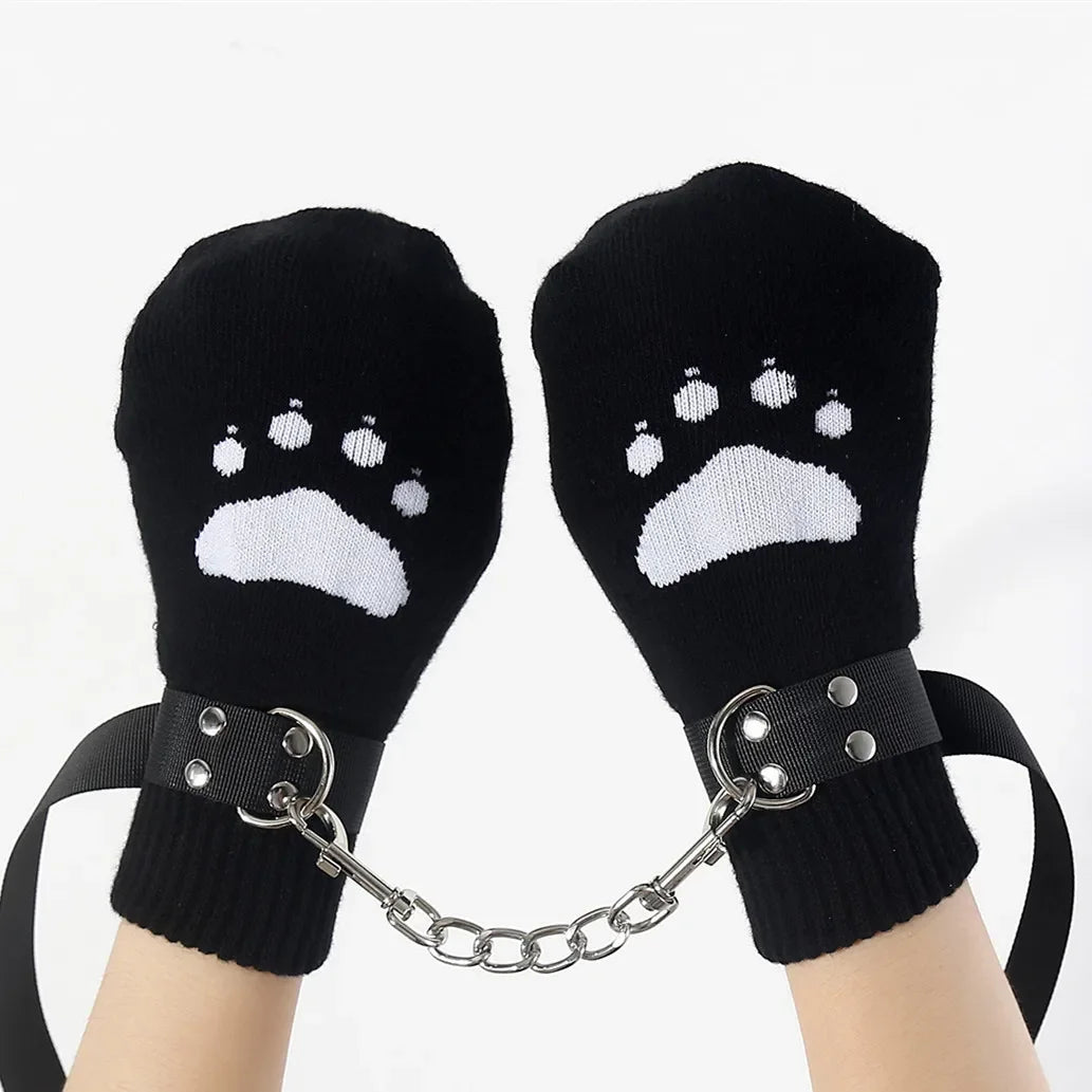 Black mittens with white paw prints, connected by a chain, worn on hands