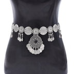 Silver coin waist belt with intricate round designs and dangling charms on a mannequin