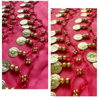 Gold coin and bead garland with pink thread on a bright pink fabric background