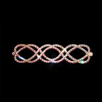 Gold hair clip with sparkling rhinestones in an interwoven design on black background