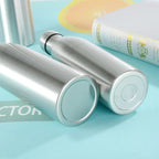 Stainless steel insulated water bottles on a blue surface with a book nearby