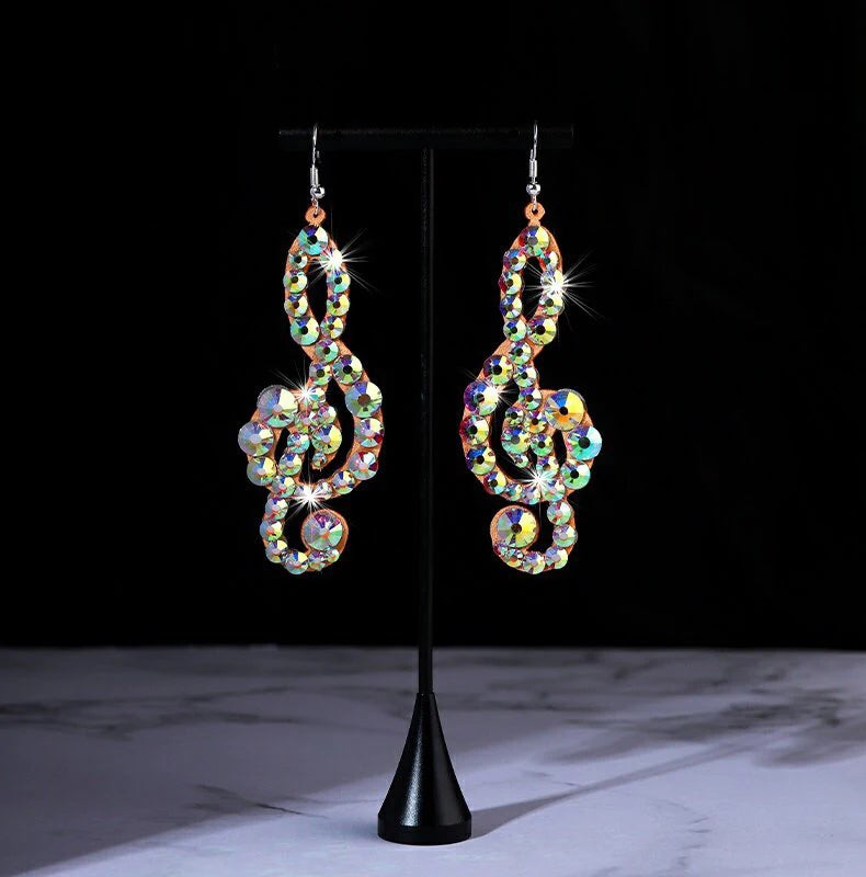 Rhinestone treble clef earrings with multicolor crystals on display stand, black background