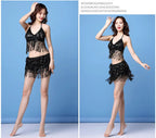 Woman modeling black sequin fringe two-piece dance costume against blue background