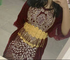 Woman in maroon traditional dress with gold embroidered patterns and ornate gold belt